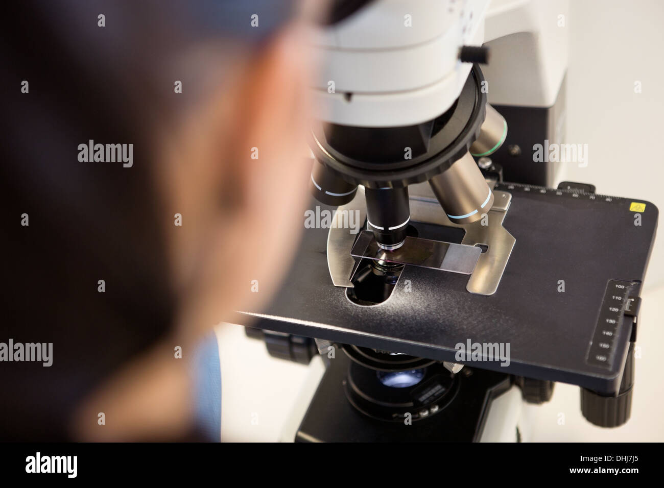 Scienziato usando microscopio in laboratorio Foto Stock