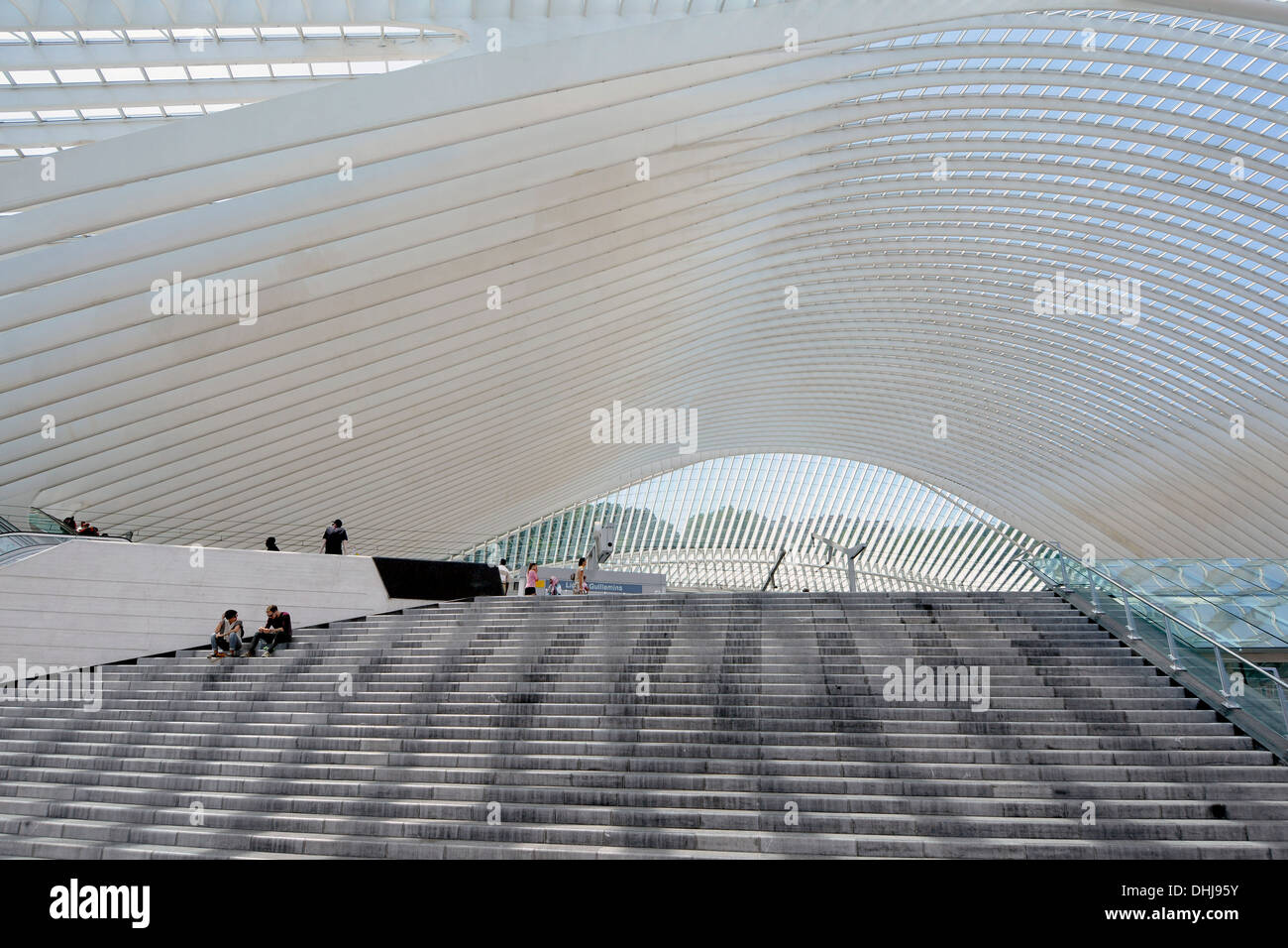 Singolare edificio moderno e tetto di vetro a Liegi in Belgio stazione ferroviaria gettando ombre sui gradini all'ingresso principale al pubblico per il trasporto ferroviario di viaggiatori Foto Stock