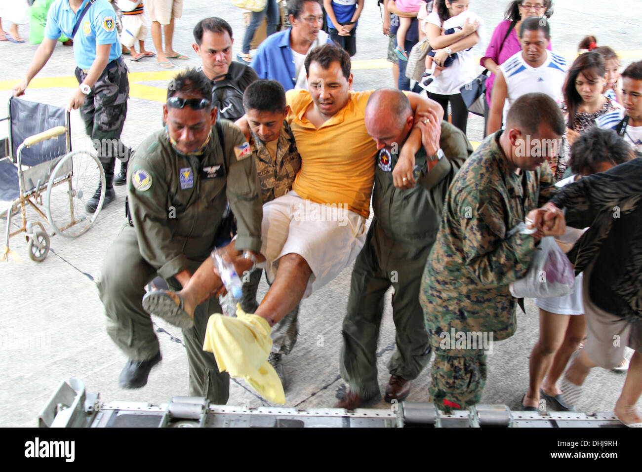 Manila nelle Filippine . Xi Nov, 2013. Marines americani portano un ferito uomo filippino su un KC-130J Super Hercules velivoli da trasporto a Villamor Air Base Novembre 11, 2013 a Manila, nelle Filippine. Gli Stati Uniti hanno unito gli sforzi di rilievo a seguito della devastazione causata da Super Typhoon Haiyan che si crede di avere ucciso 10.000 persone attraverso le isole filippine. Foto Stock
