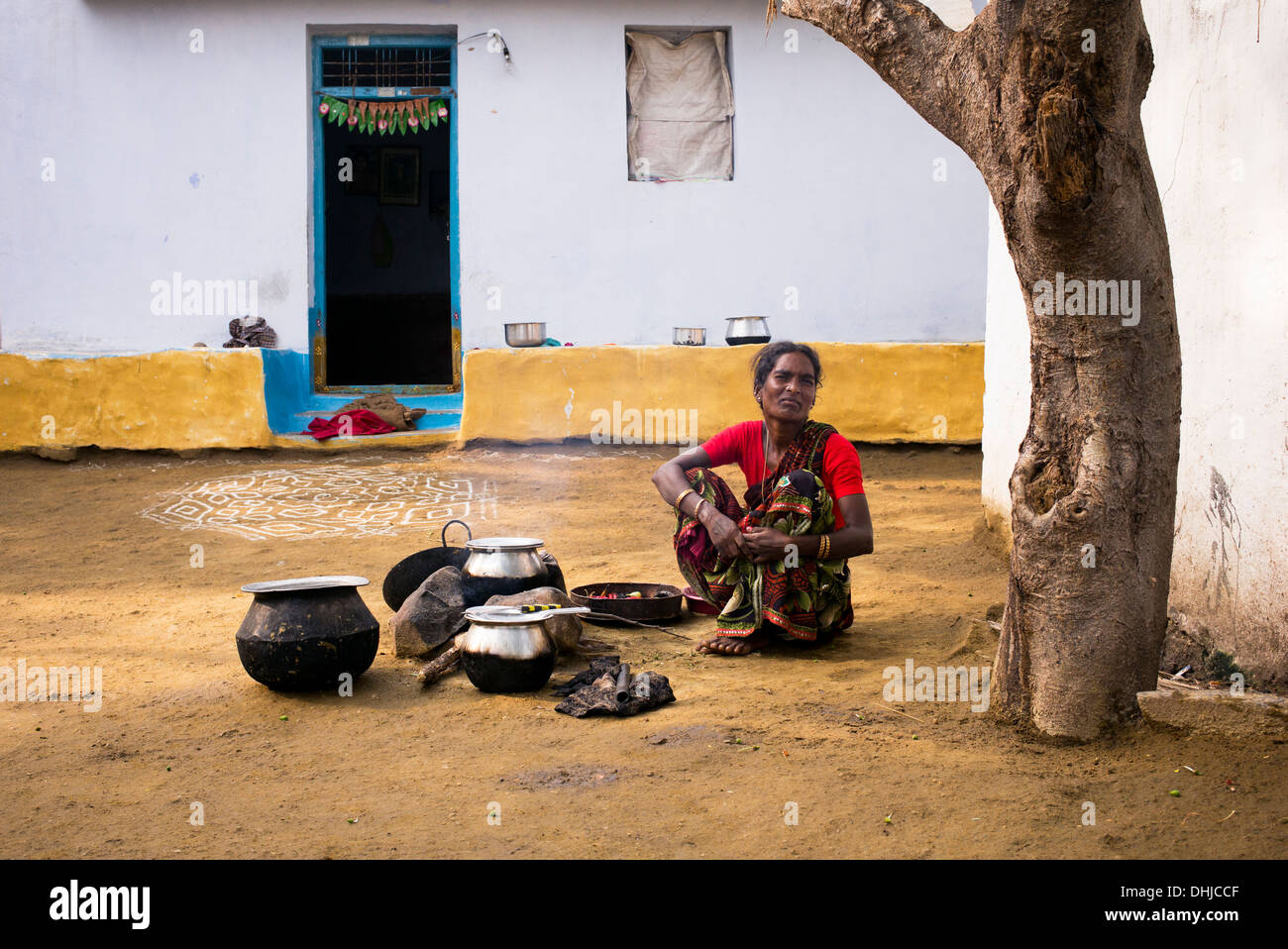 Donna indiana la cottura del riso su un fuoco aperto fuori la sua casa in un borgo rurale. Andhra Pradesh, India Foto Stock