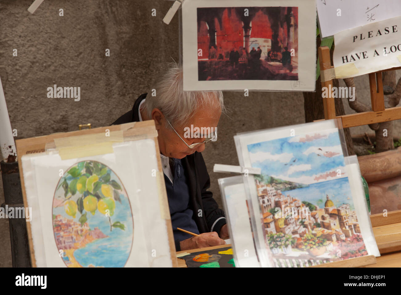 Un artista che lavora presso il suo stand in Amalfi, Italia. Foto Stock