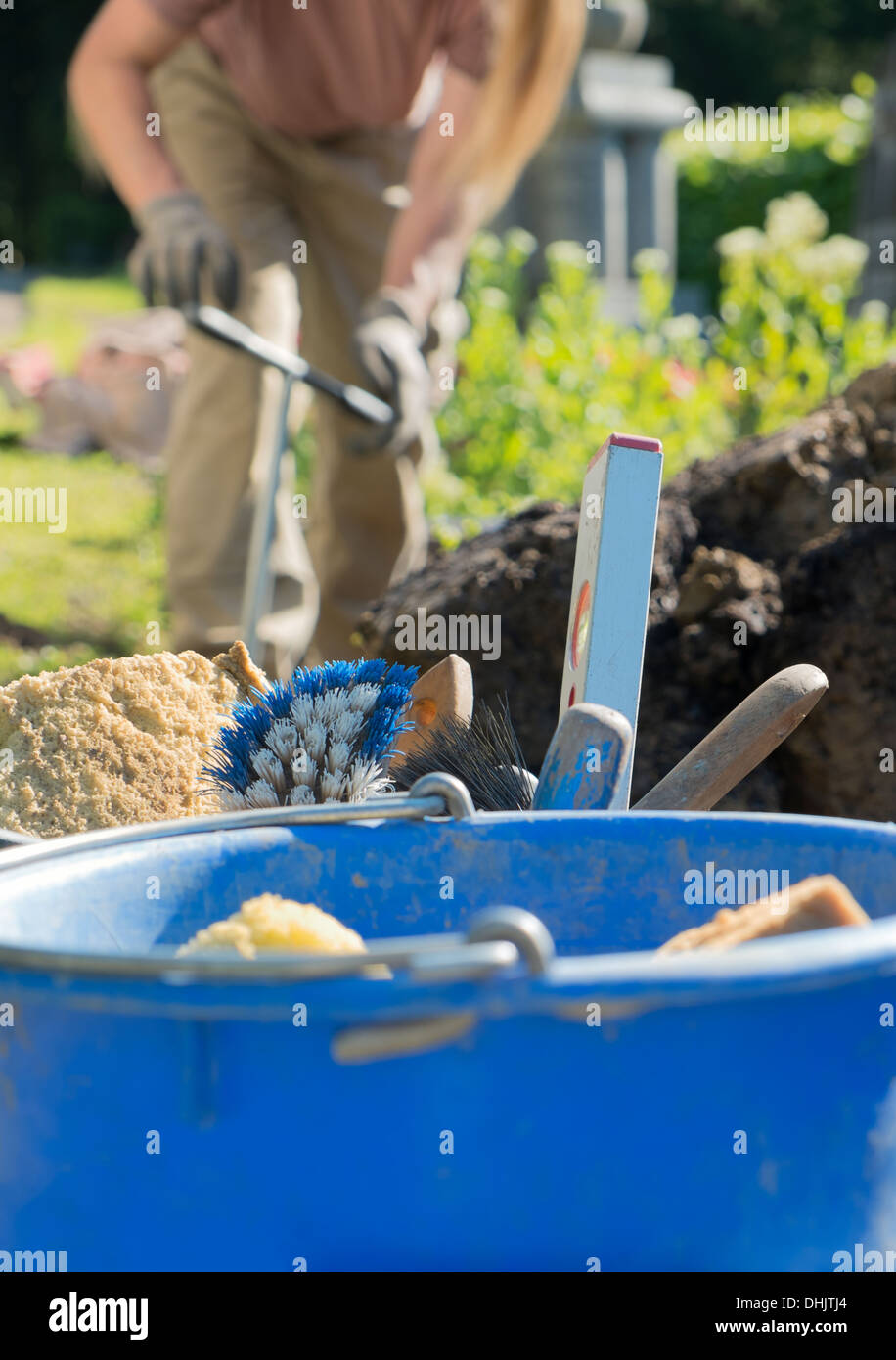 Scalpellino lavorando su una tomba, strumenti per la muratura e la cementificazione Foto Stock