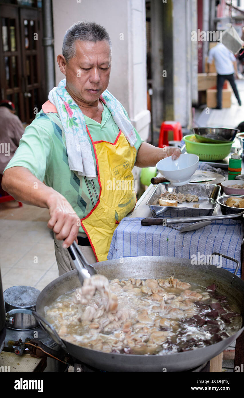 Venditore ambulante su un sud-est asiatico di stallo street, vendita di trippa bollita (intestini) Foto Stock