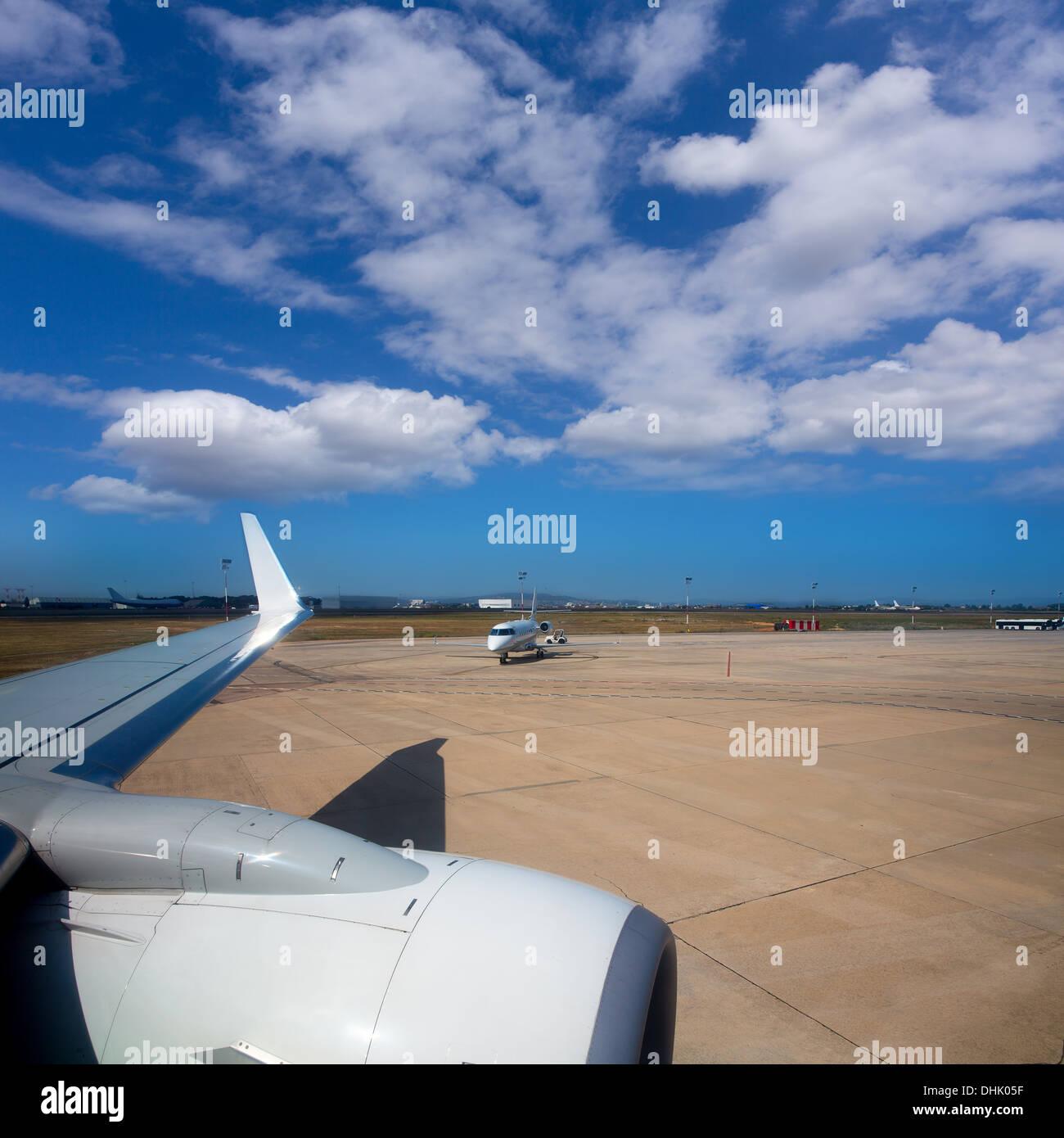 Ala di aeroplano in aeroporto con aeromobili con sfondo blu cielo Foto Stock