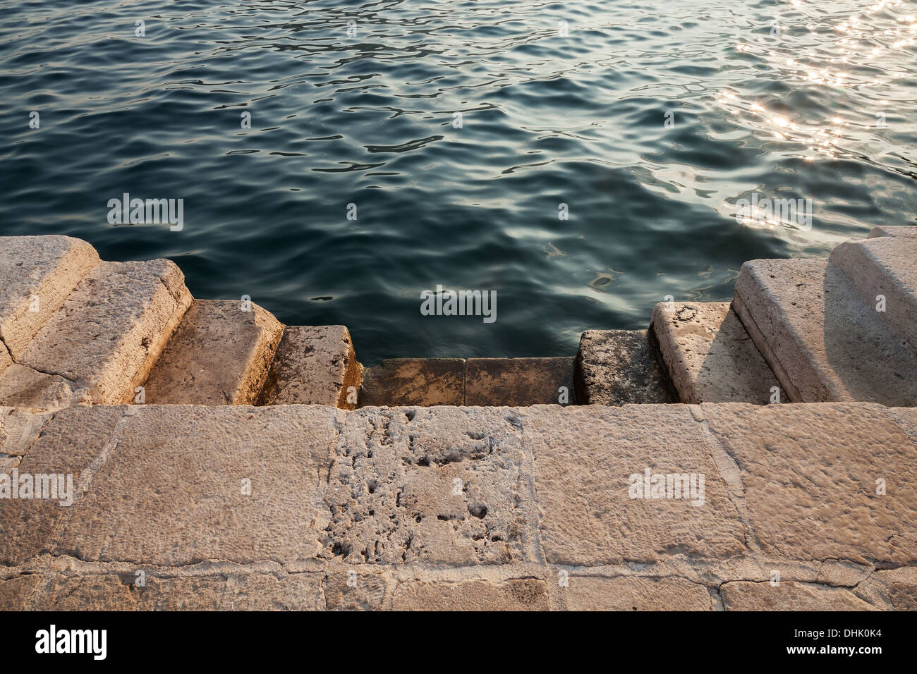 Scale di pietra al mare scintillante acqua. Città Perast, Montenegro Foto Stock