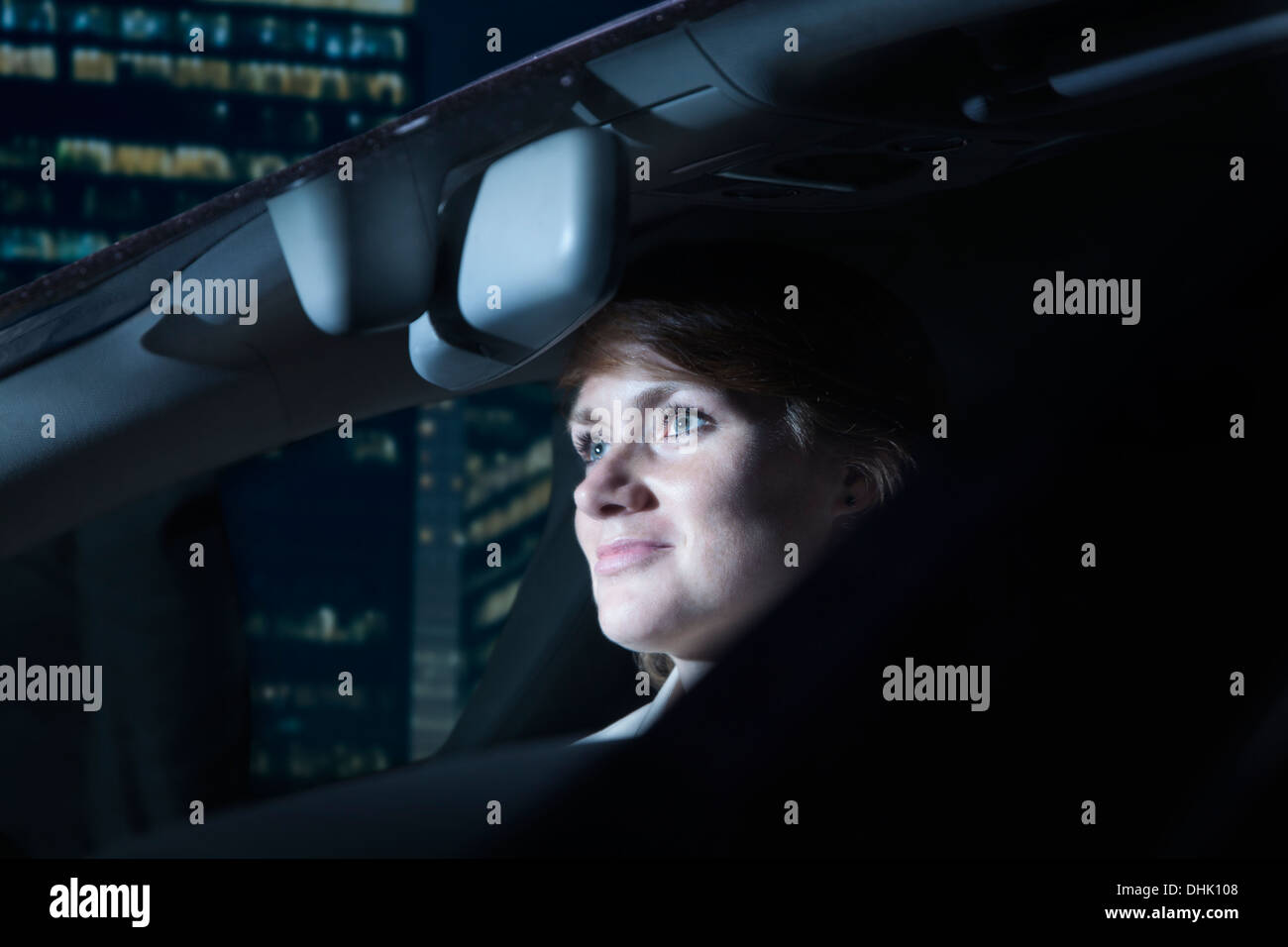 Imprenditrice guidare di notte nella città Foto Stock