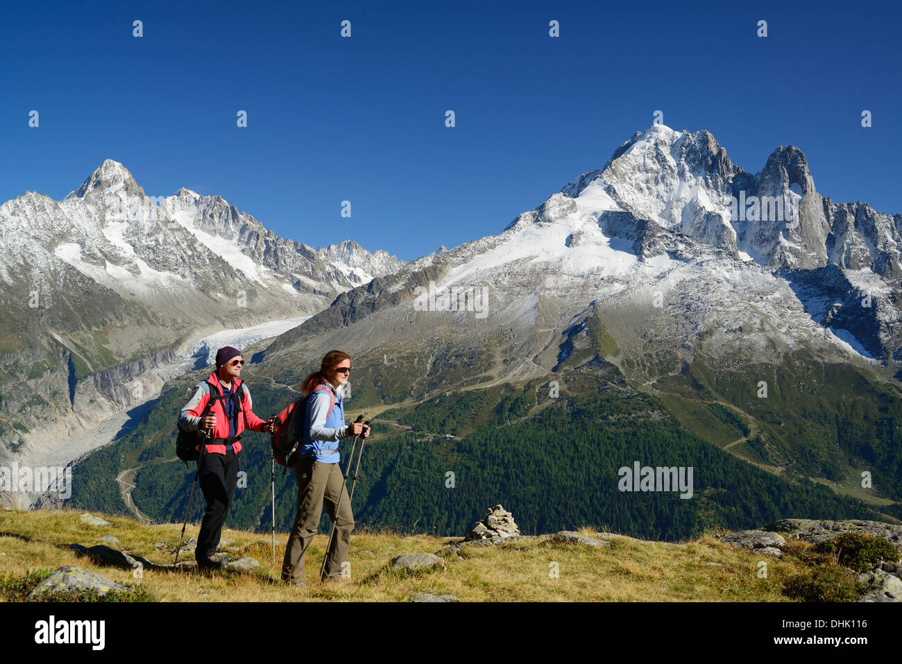 Donna e uomo escursionismo con vista dell Aiguille du Chardonnet, Aiguille d' Argentiere, Aiguille Verte e Grand Dru, Mont Blanc gamma Foto Stock