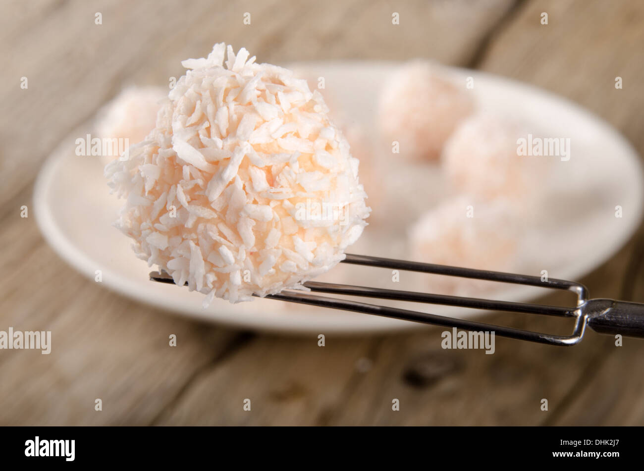 Home fragole fatta pralina con scaglie di noce di cocco su una forcella Foto Stock