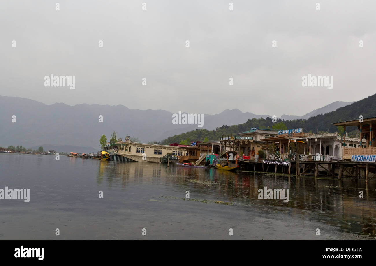 Linea di case galleggianti lungo la riva del lago Dal a Srinagar in Kashmir, India, con shikaras (piccole e strette barche in legno) Foto Stock