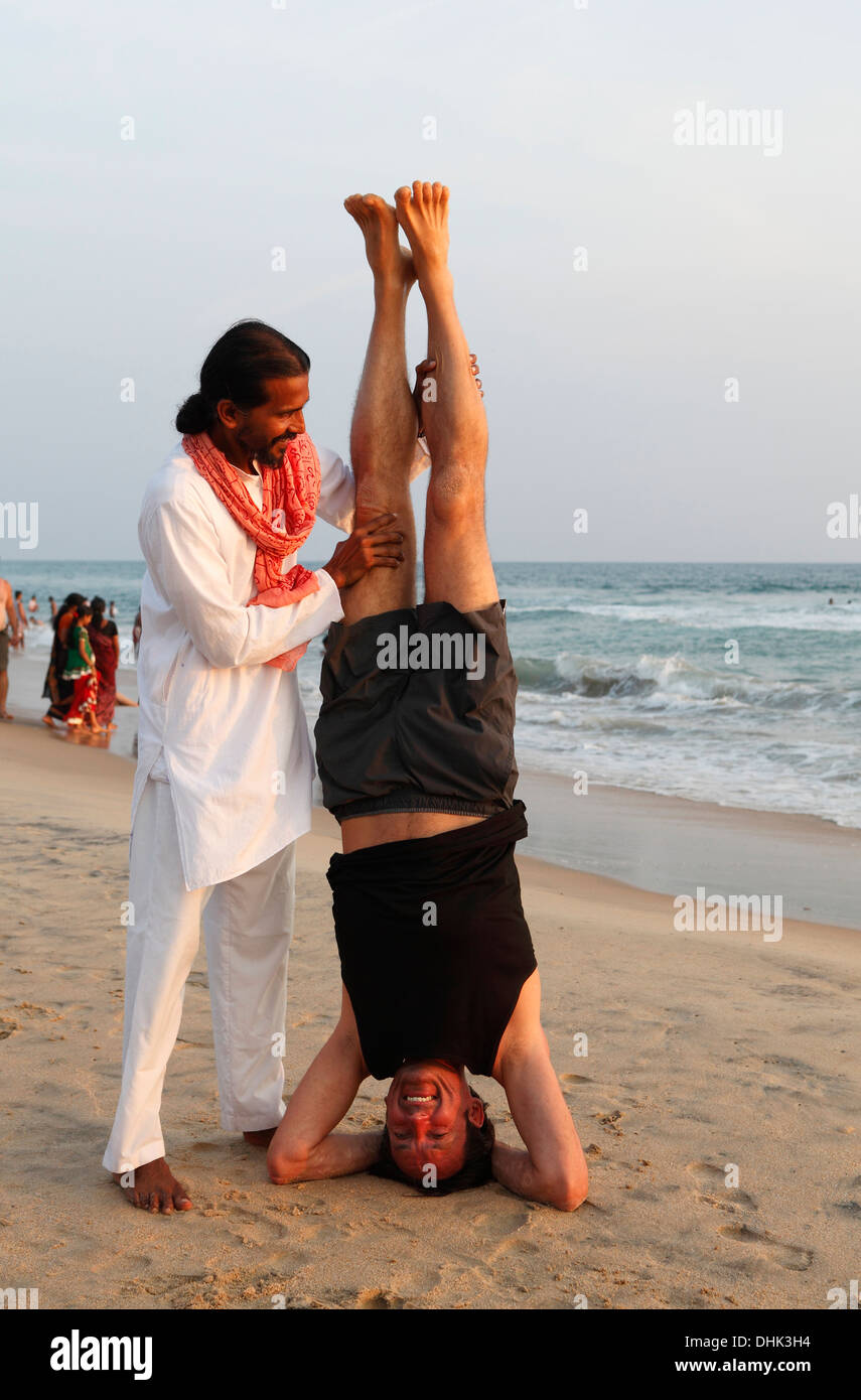 Yoga indiano maestro e allievo sulla spiaggia di Varkala,l'India. Foto Stock