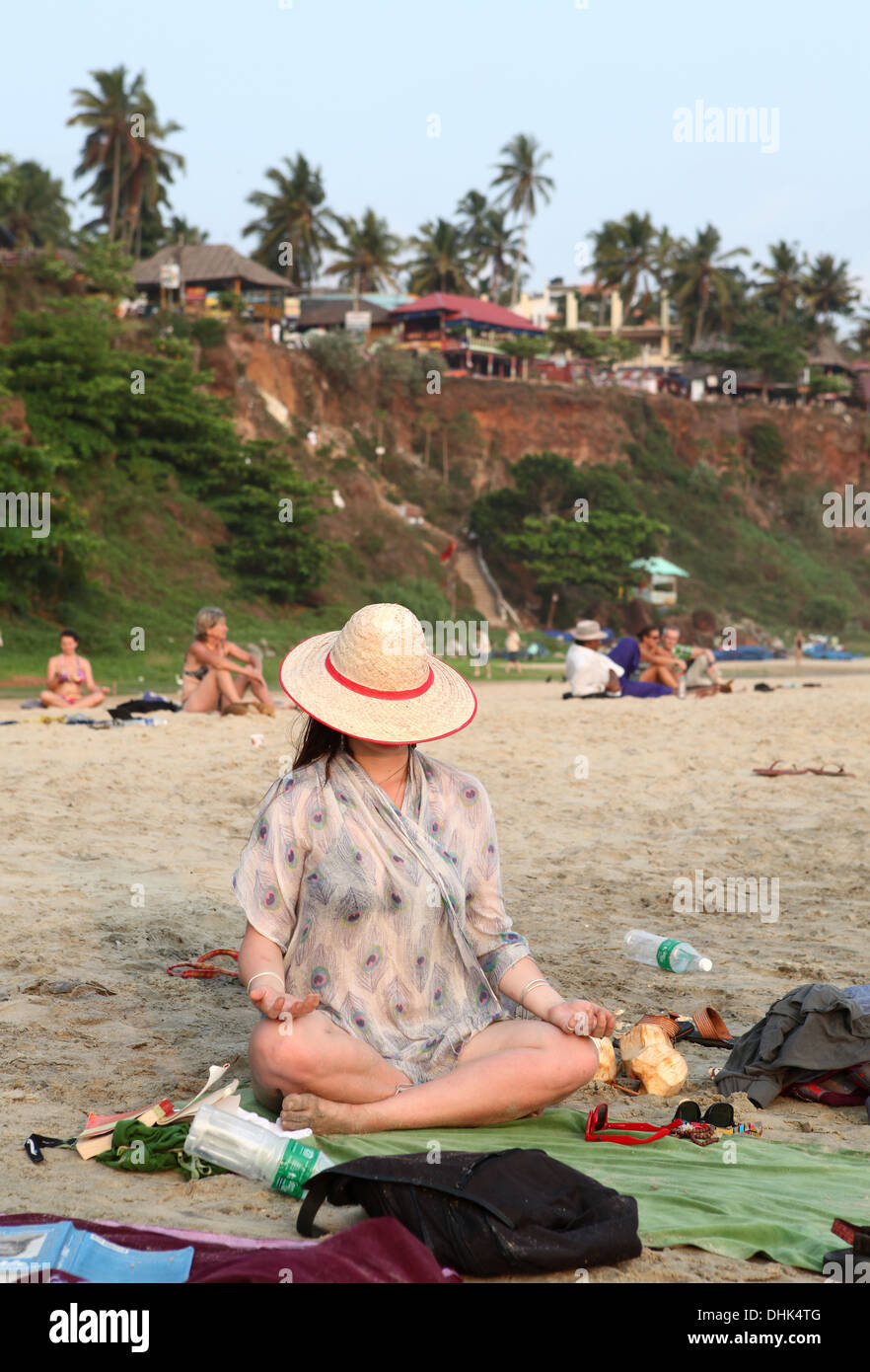 Giovane donna in una posizione di meditazione sulla spiaggia di Varkala,Kerala, India Foto Stock