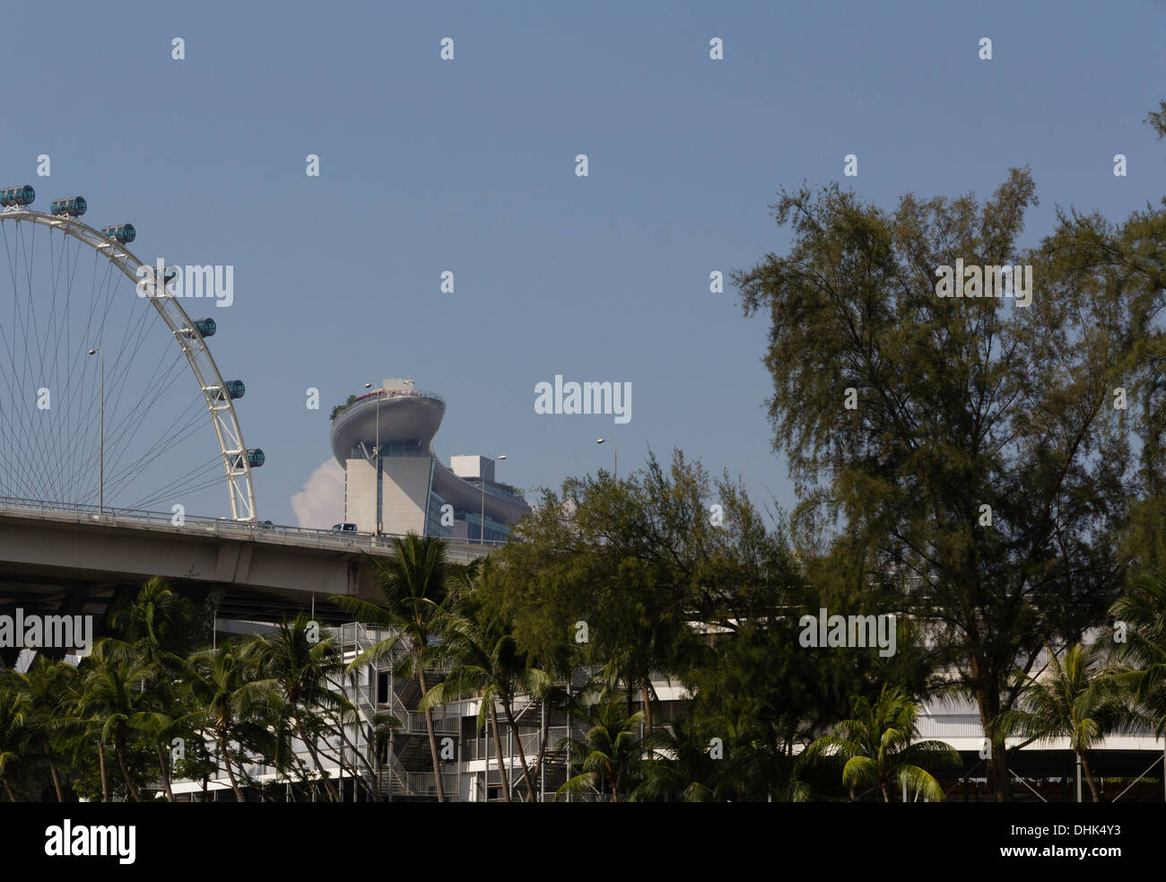 Vista del Singapore Flyer, Marina Bay Sands e Benjamin Sheares Bridge in Singapore, con un numero di alberi di fronte Foto Stock