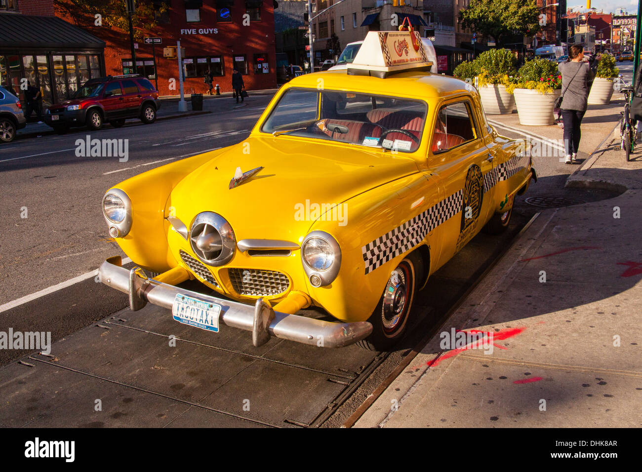 Vintage Yellow taxi cabina (1950 Studebaker) al di fuori della Caliente ristorante messicano, il Greenwich Village di New York City, U.S.A. Foto Stock