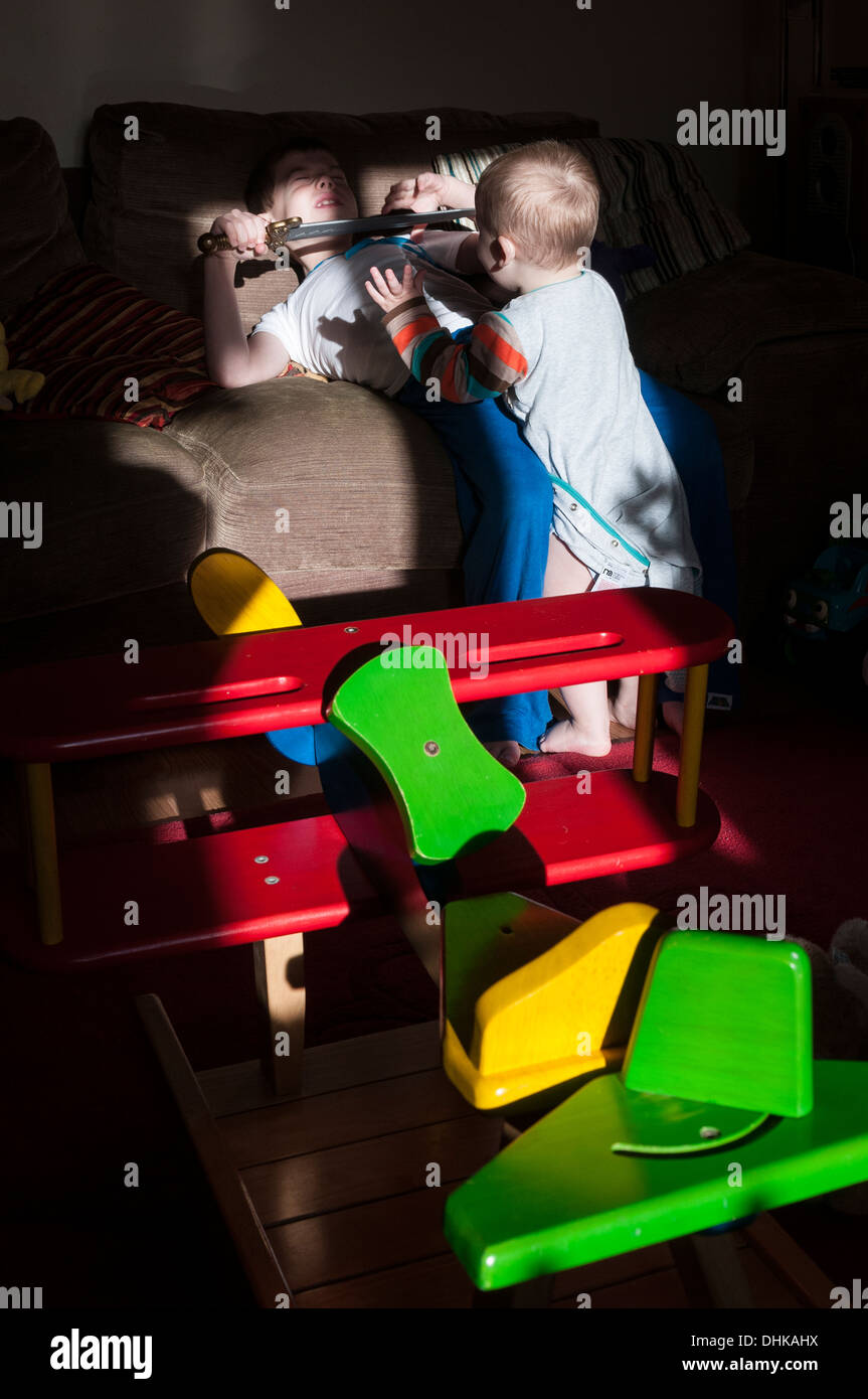 Gioco Bimbi combattimenti con il fratello, giocattoli colorati Foto Stock