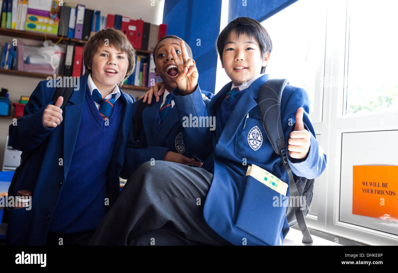 Un trio di studenti multirazziali in uniforme, Londra, Inghilterra, Regno Unito. Foto Stock