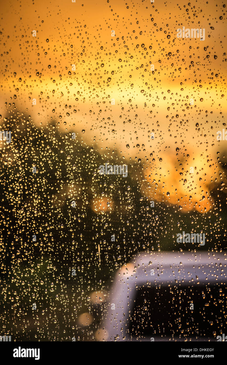 La pioggia su una finestra durante il tramonto Foto Stock