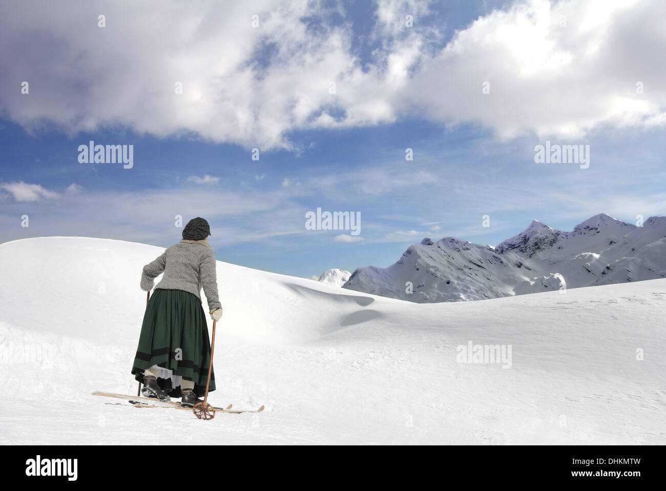 Sciatore femmina in un mantello e vecchi sci di legno Foto Stock
