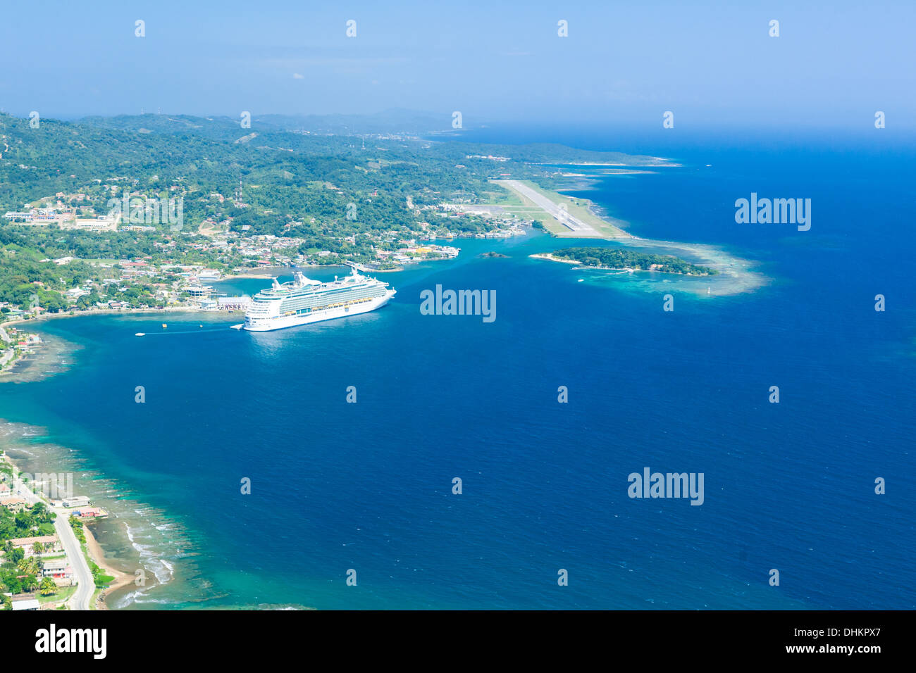 Foto aerea di cruieship ormeggiata al Porto di Roatan aeroporto con pista di atterraggio per aerei in background. Isola di Roatan in Honduras Foto Stock