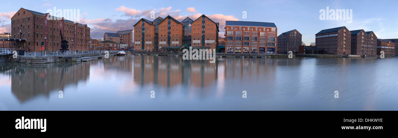 Tramonto sul dock a Gloucester, con i mattoni vecchi edifici di magazzino essendo riflesso nell'acqua. Foto Stock