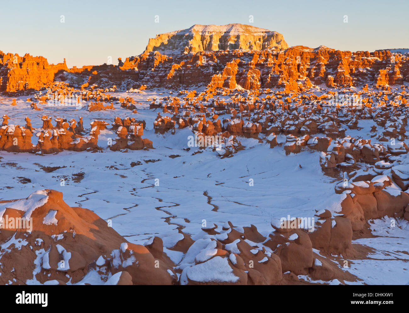 Nel tardo pomeriggio sole colpisce una stringa di strane formazioni di roccia in mezzo alla neve in Goblin Valley State Park, Utah Foto Stock