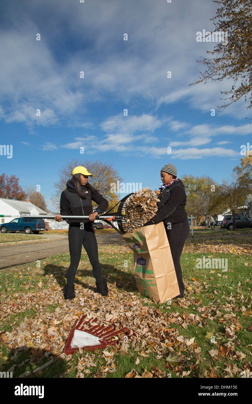 Alta scuola studenti volontari foglie di rake per anziani Foto Stock
