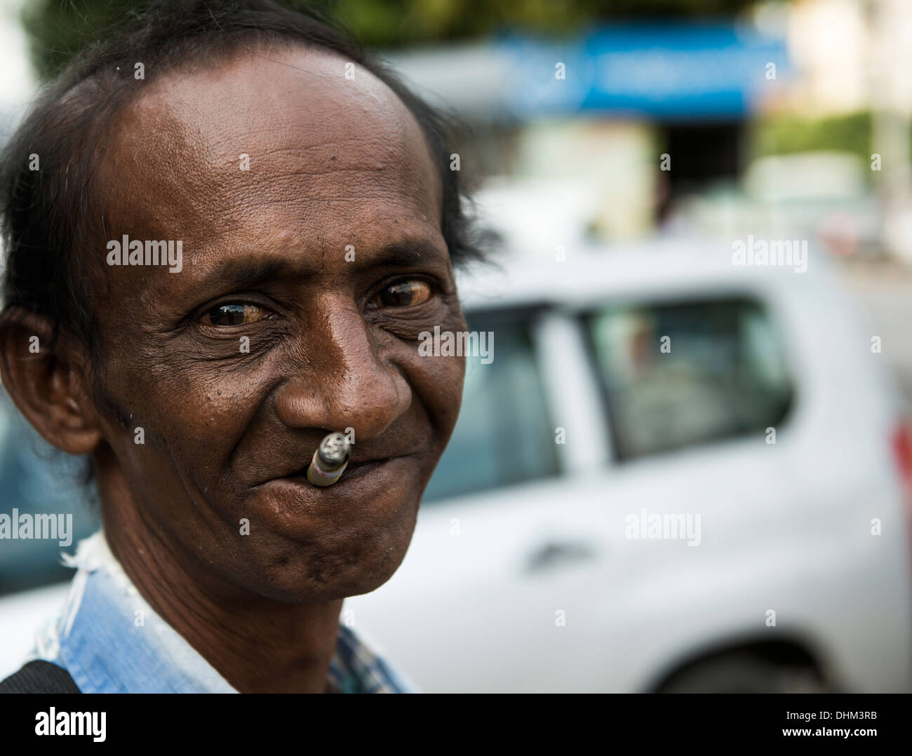 Un indiano uomo birmano godendo di fumare la sigaretta. Foto Stock