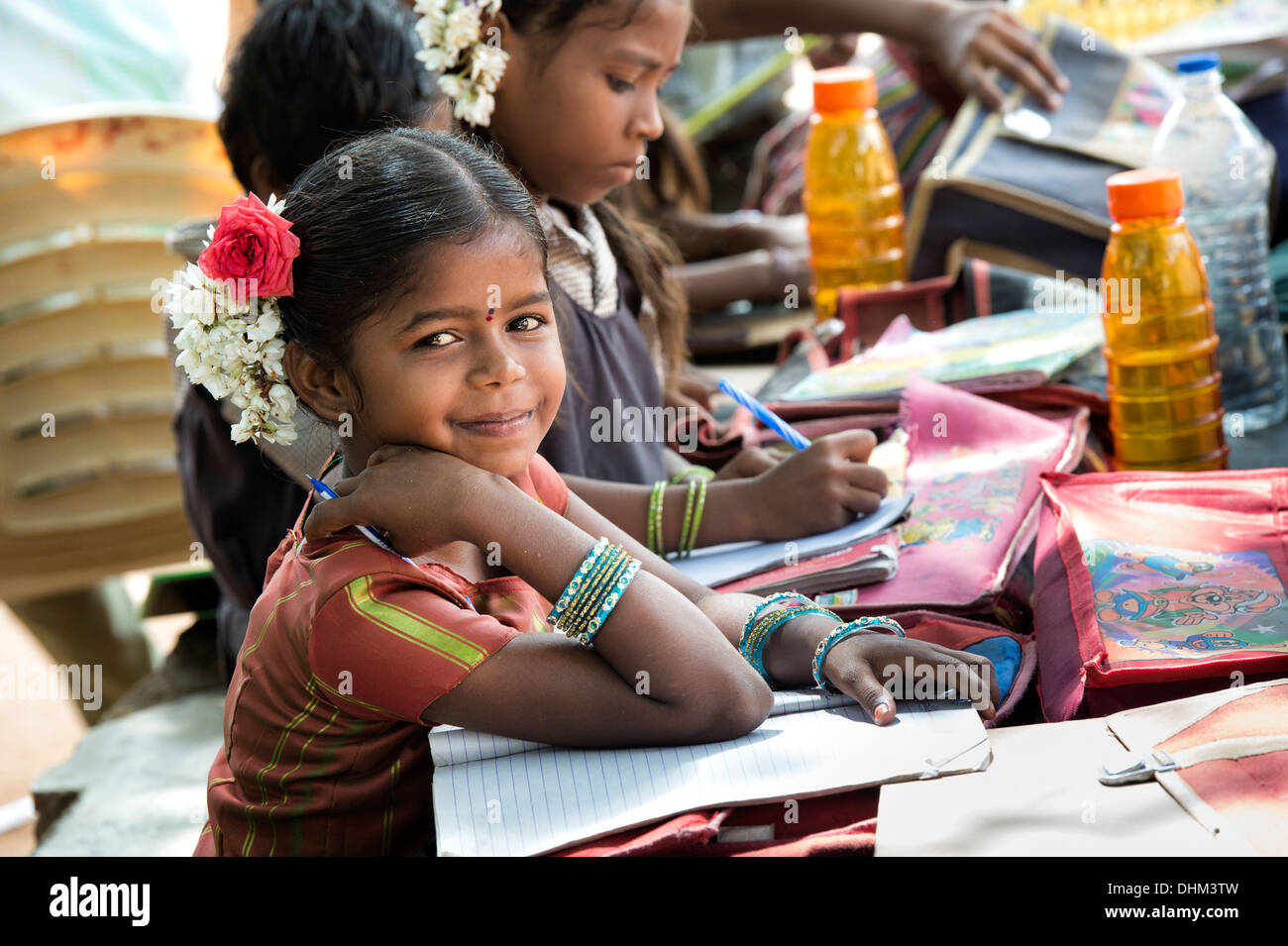 Rurale villaggio indiano ragazze della scuola iscritto nei libri in una classe esterna. Andhra Pradesh, India, il fuoco selettivo. Foto Stock