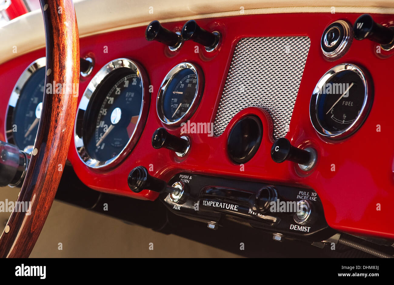 Rosso antico cruscotto di automobile con una grande ruota e diversi pulsanti e visualizzazioni meccaniche Foto Stock