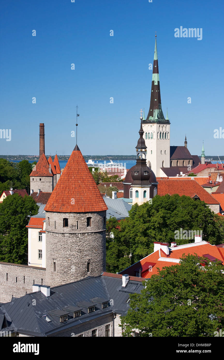 Cityscape foto scattata nella Città Vecchia di Tallinn, Estonia. Case con il tetto rosso e la chiesa di San Olaf in background. Foto Stock