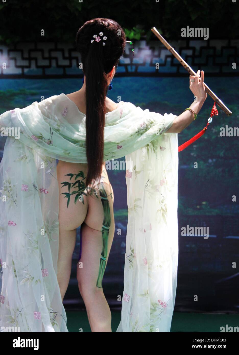 Verniciatura della scocca un corpo pittura modello mostra fuori la sua creatività durante la riproduzione di un flauto di bambù nel Monte Huangshan in Cina Cina - Maggio 2012 Foto Stock