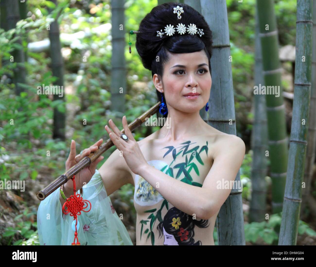 Verniciatura della scocca un corpo pittura modello mostra fuori la sua creatività durante la riproduzione di un flauto di bambù nel Monte Huangshan in Cina Cina - Maggio 2012 Foto Stock