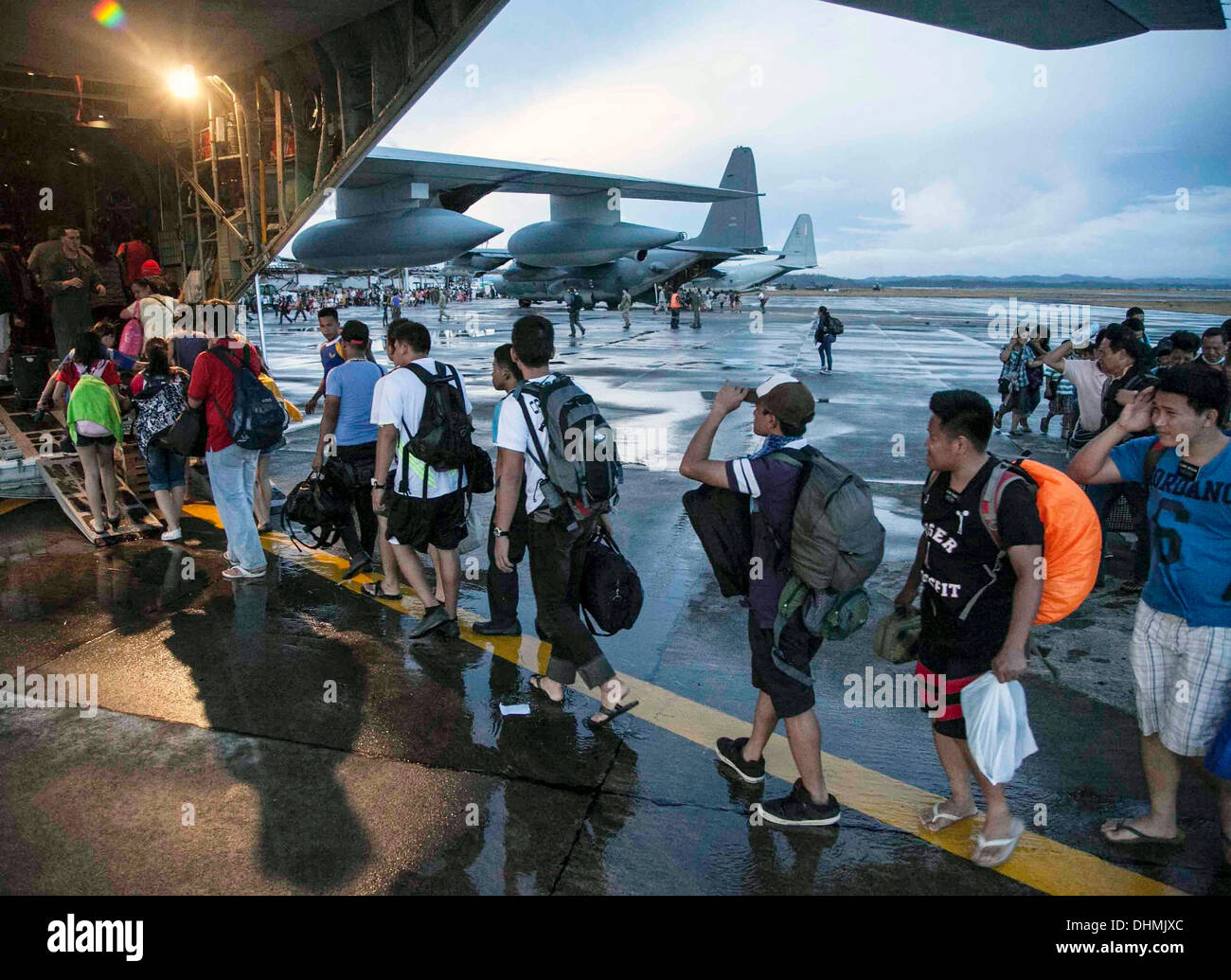 I civili sfollati dal tifone Haiyan bordo un U.S. Marine Corps KC-130J Super Hercules aeromobile per evacuazione a Manila Novembre 13, 2013 a Tacloban Air Base, Filippine. Il super typhoon hanno devastato ampie zone delle isole e ucciso come molti come 10.000 persone. Foto Stock