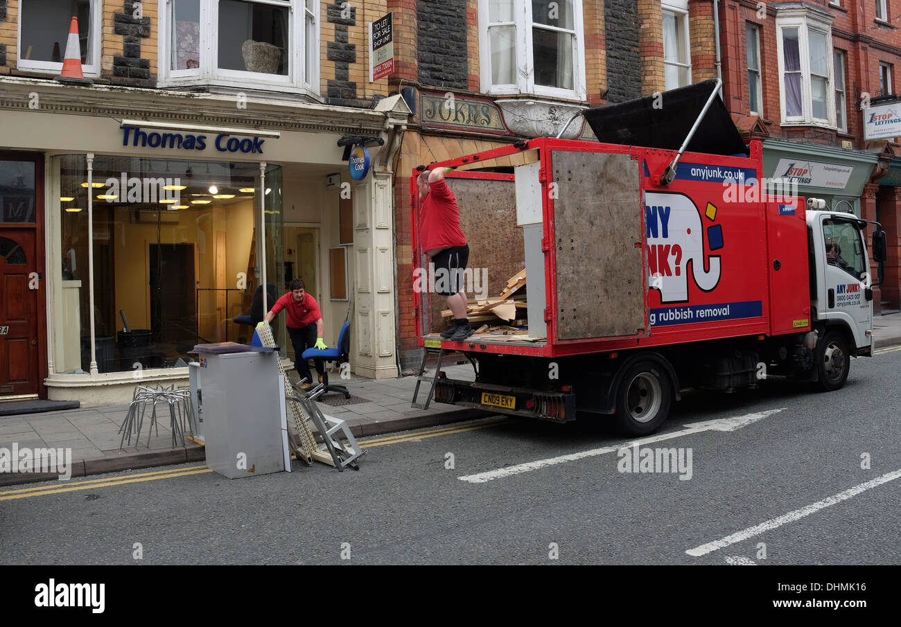 Gli uomini che lavorano per Anyjunk.co.uk svuotare i mobili per ufficio da una posizione chiusa verso il basso il ramo di Thomas Cook Agenti di viaggio REGNO UNITO Foto Stock