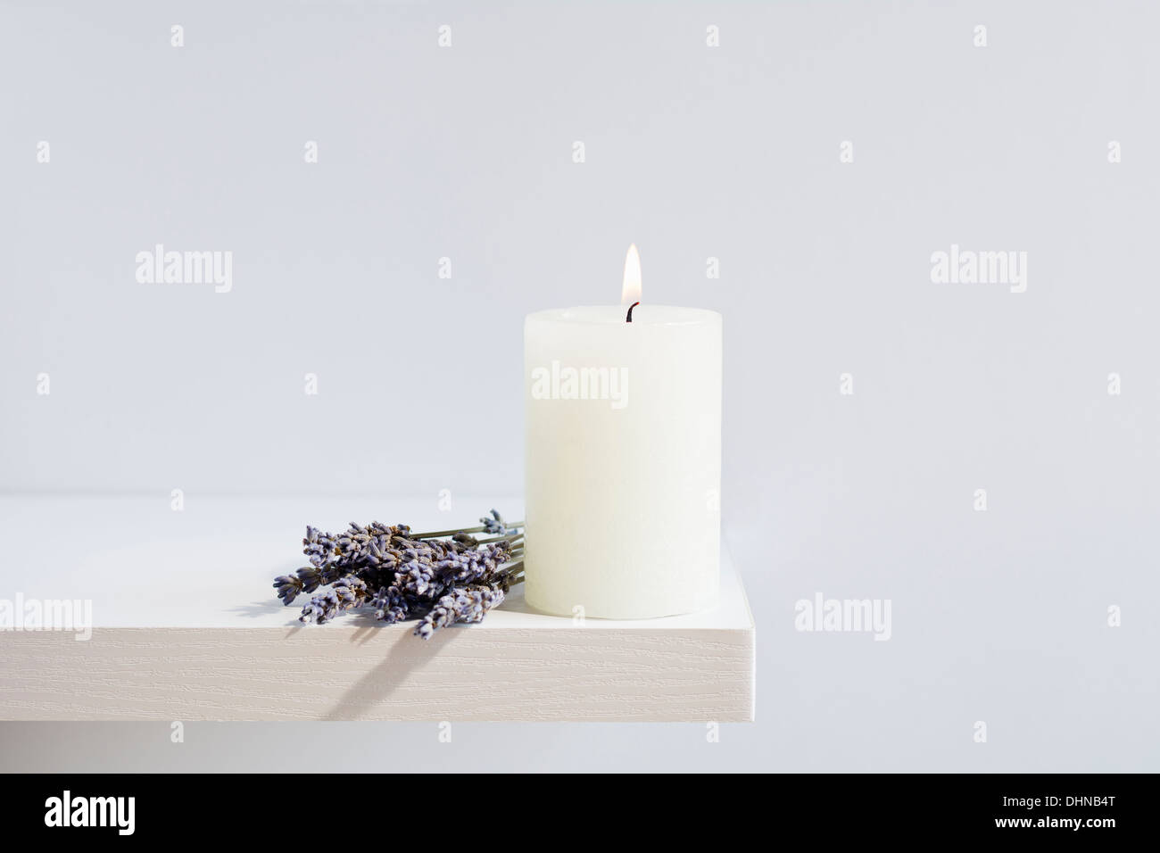 Fiori di lavanda con candela che brucia Foto Stock