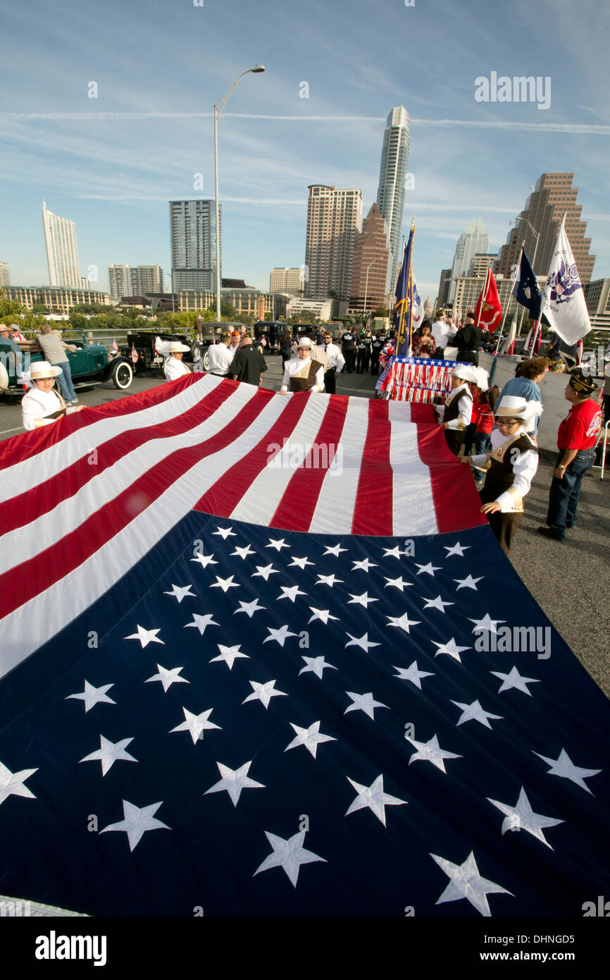 Militari e civili partecipano tenendo grande bandiera americana durante un veterano del giorno parade di Austin in Texas Foto Stock