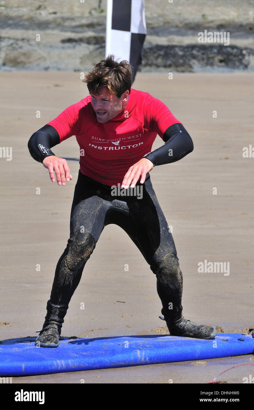 Istruttori di Surf in piedi sulla tavola da surf che mostra il corretto si muove durante una lezione sulla spiaggia di Croyde, Devon, Inghilterra, Regno Unito Foto Stock