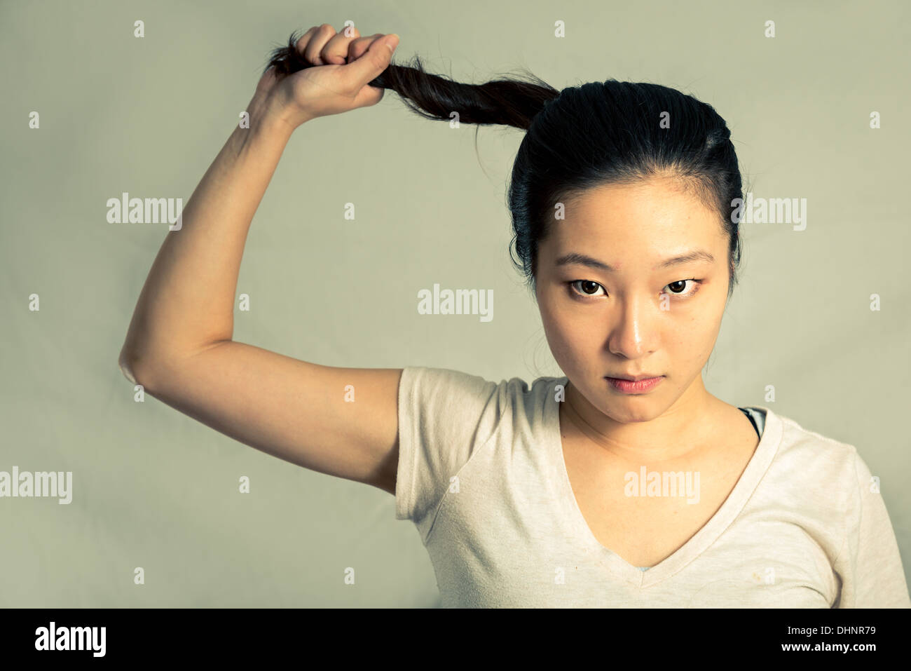 Giovane donna tirando i suoi capelli cercando frustrati, con tono di moda e lo sfondo Foto Stock
