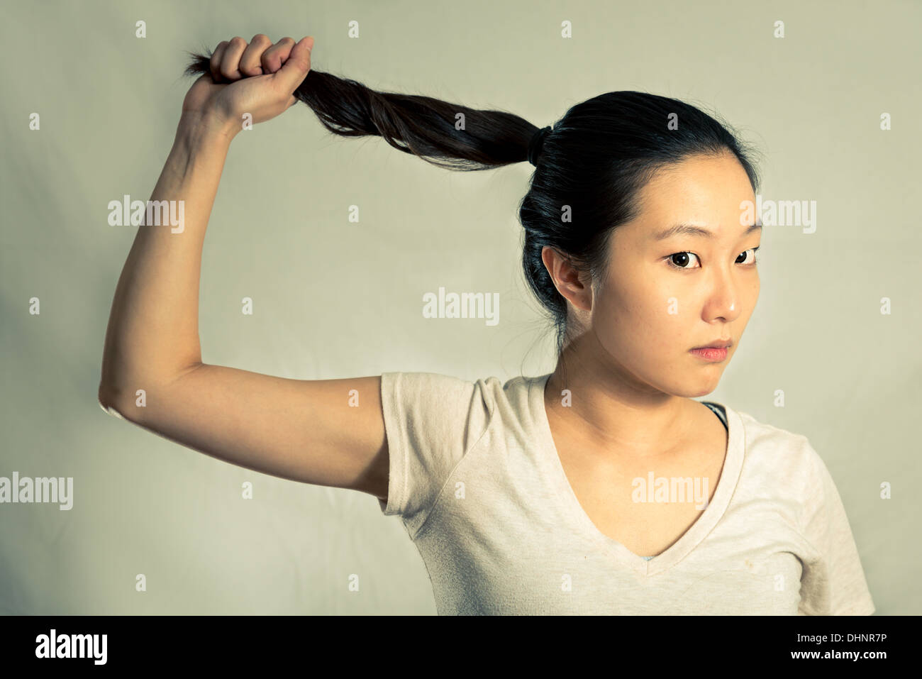 Giovane donna tirando i suoi capelli cercando frustrati, con tono di moda e lo sfondo Foto Stock