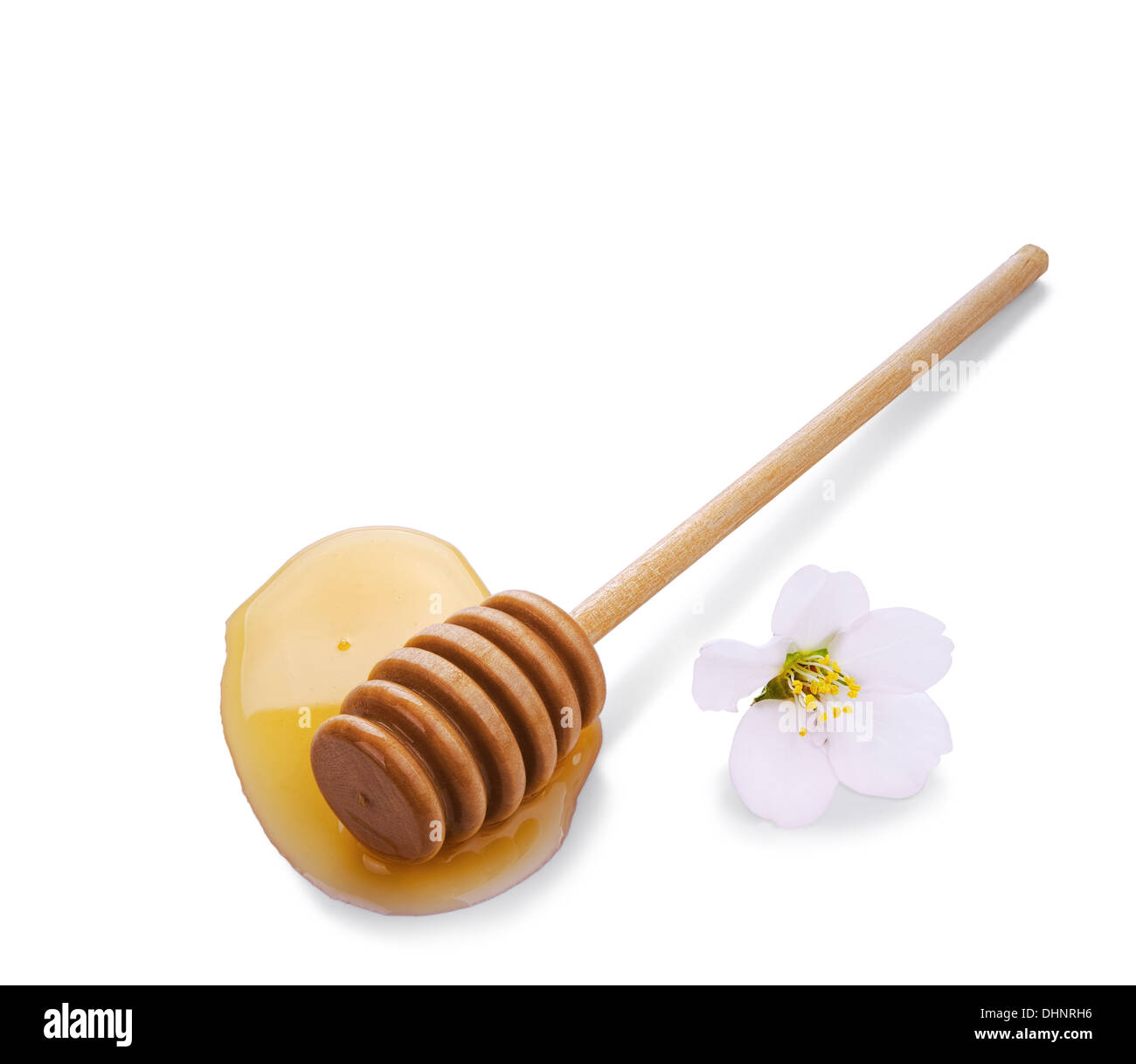 Pozza di miele con bastone di legno e fiori isolati su sfondo bianco Foto Stock