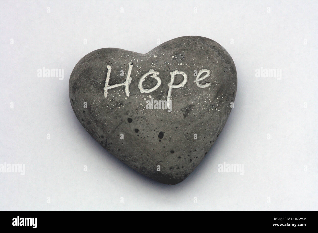 La parola "speranza" è dipinta su una piccola pietra a forma di cuore. Foto Stock