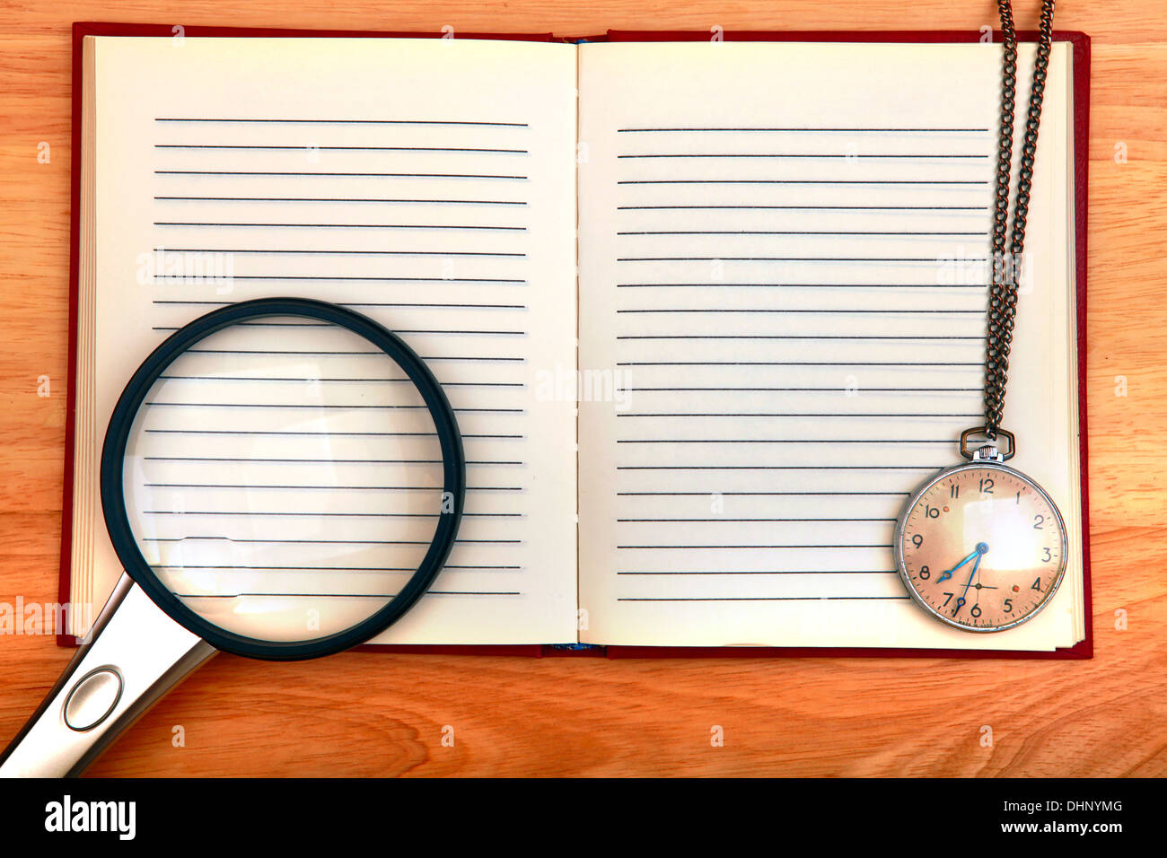 Taccuino di scrittura e lente di ingrandimento e guardare Foto Stock