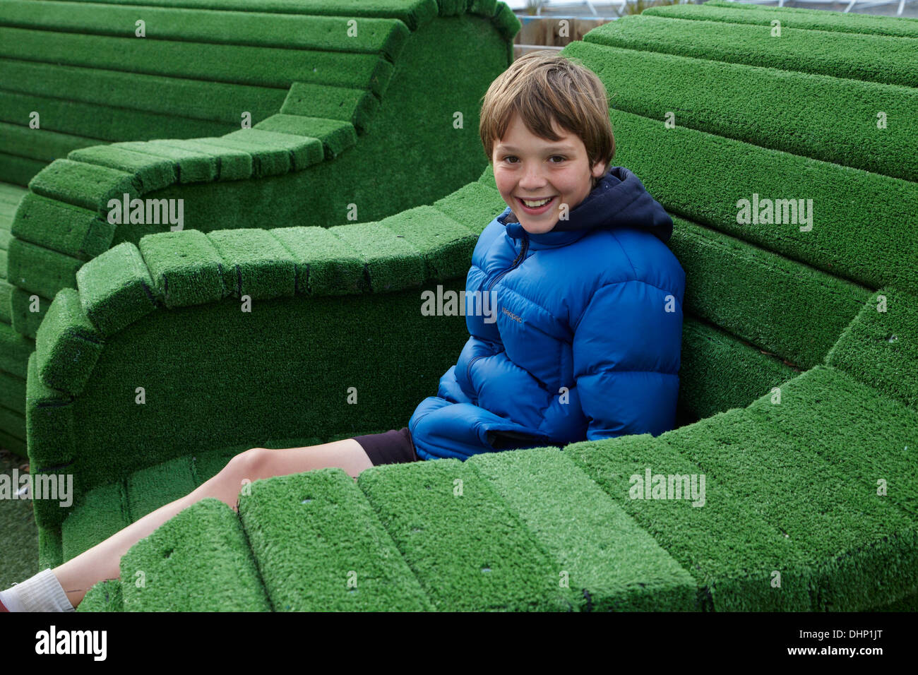 Ragazzo in gigante sedia verde, Christchurch, Canterbury, Isola del Sud, Nuova Zelanda Foto Stock