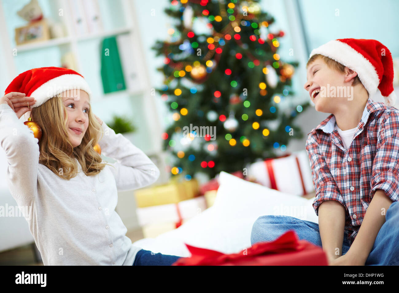 Ritratto di felice lad guardando la sua sorella cercando sul giocattolo decorativi sfere della sera di Natale Foto Stock