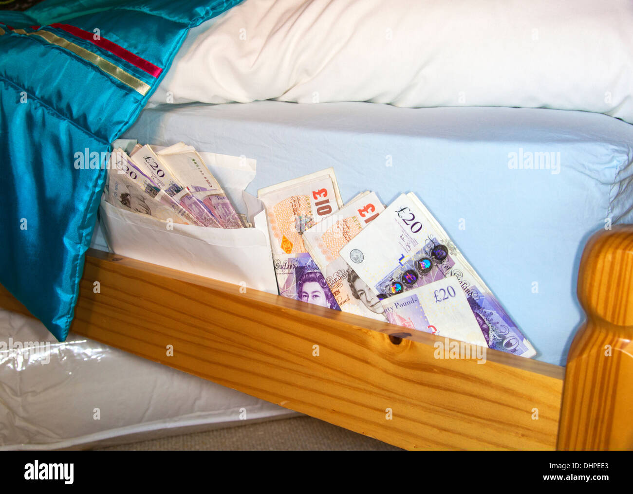 Soldi nascosti sotto il materasso Foto Stock
