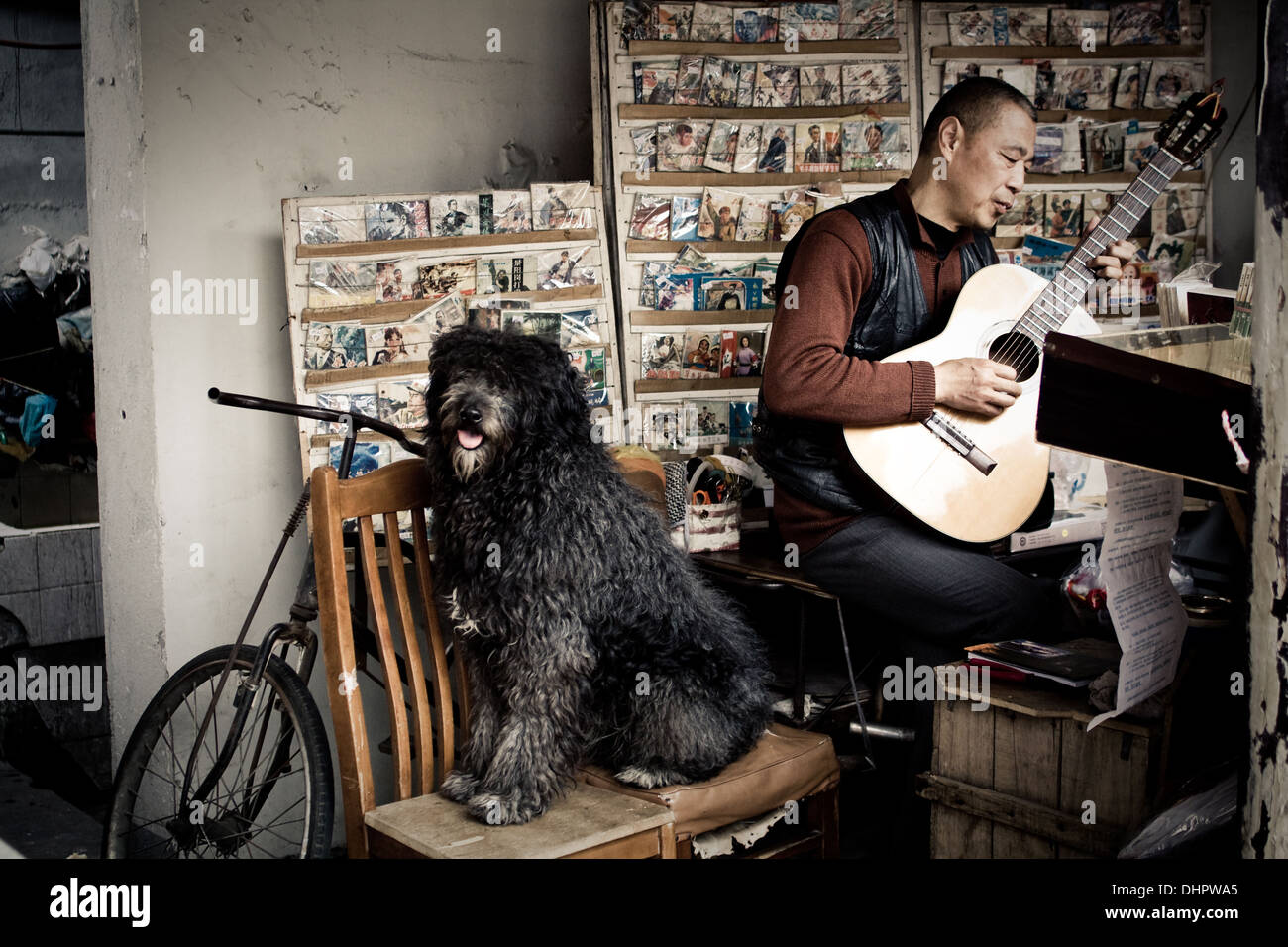 Acquista il lavoratore e il cane svolgere la loro musica per la strada da loro record shop, accogliendo i clienti con melodia. Foto Stock