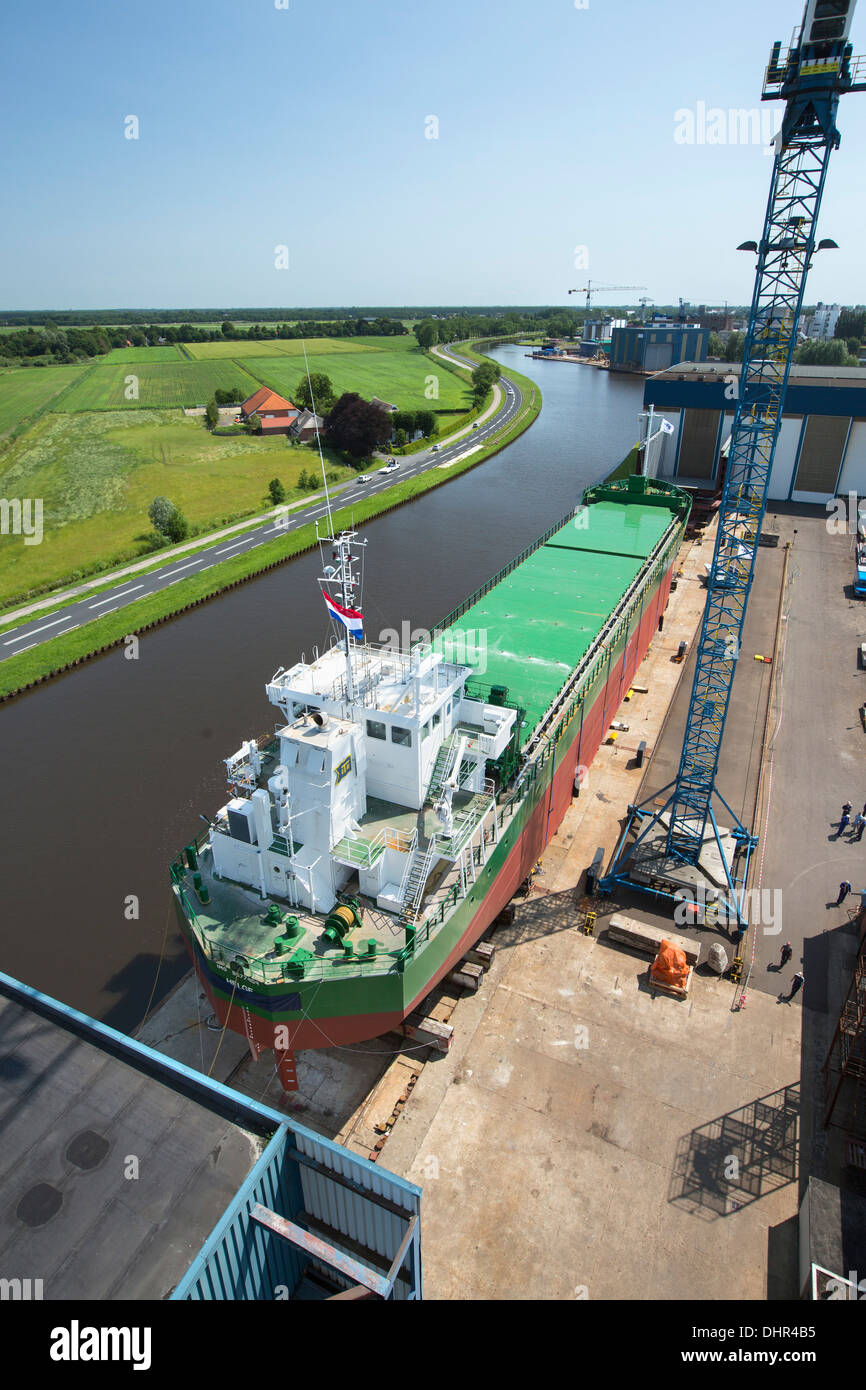 Paesi Bassi, Westerbroek, lancio di general cargo nave presso il Ferus Smit cantiere navale. Canale chiamato Winschoterdiep. Vista aerea Foto Stock