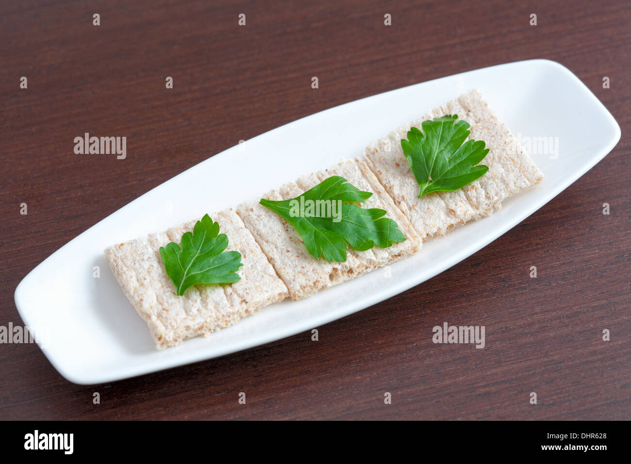 La dieta il pane con il prezzemolo su una piastra Foto Stock