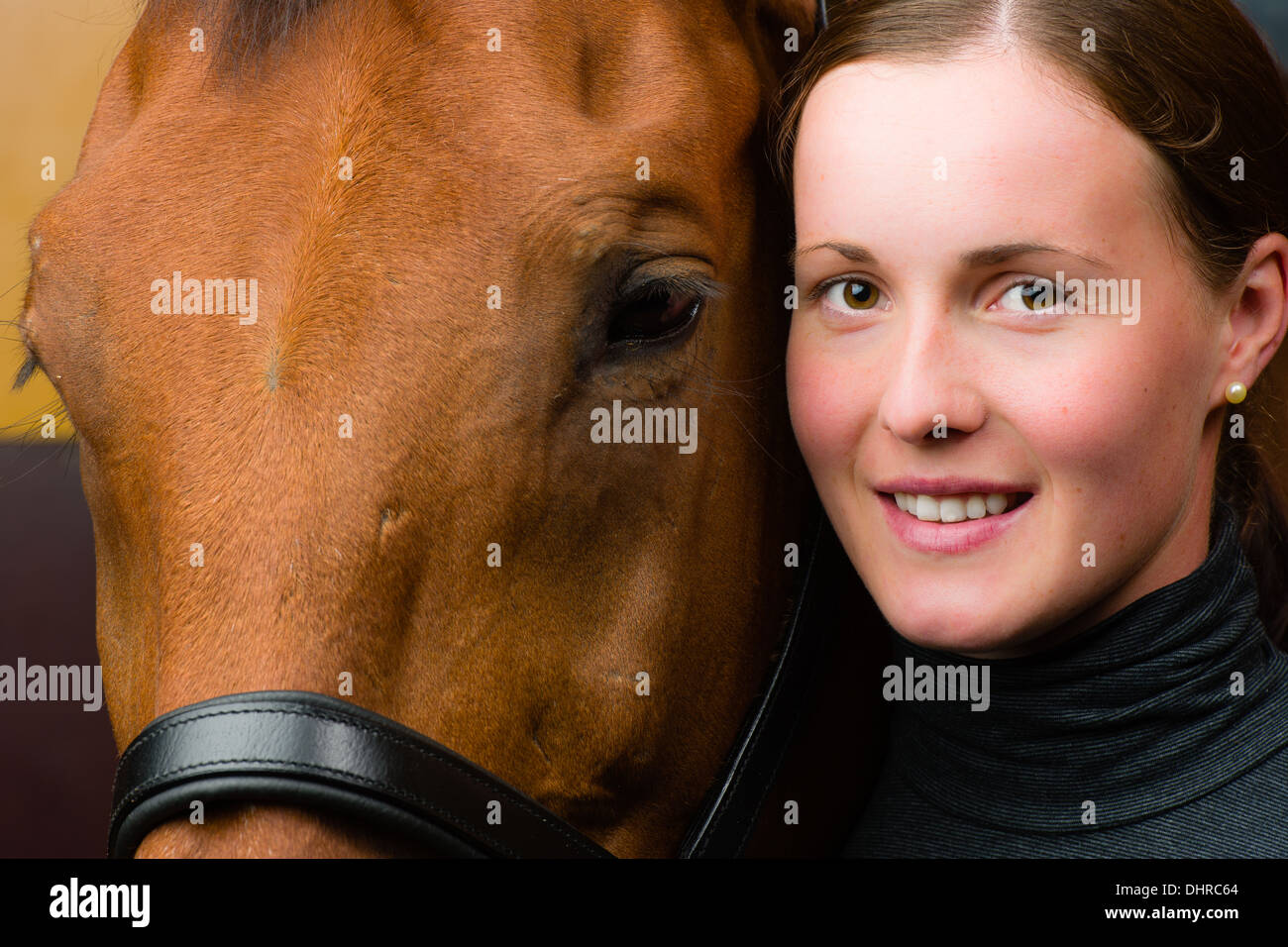 Donna e cavallo insieme, donna guarda verso la telecamera, formato con orizzonte di riferimento Foto Stock