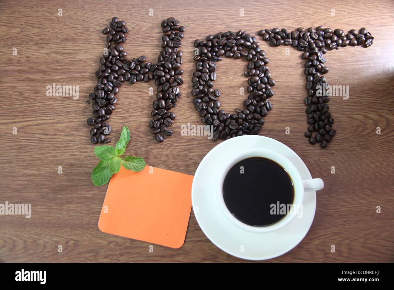 I concetti che White tazza da caffè e carta nota scritta arancione che caldo. Foto Stock