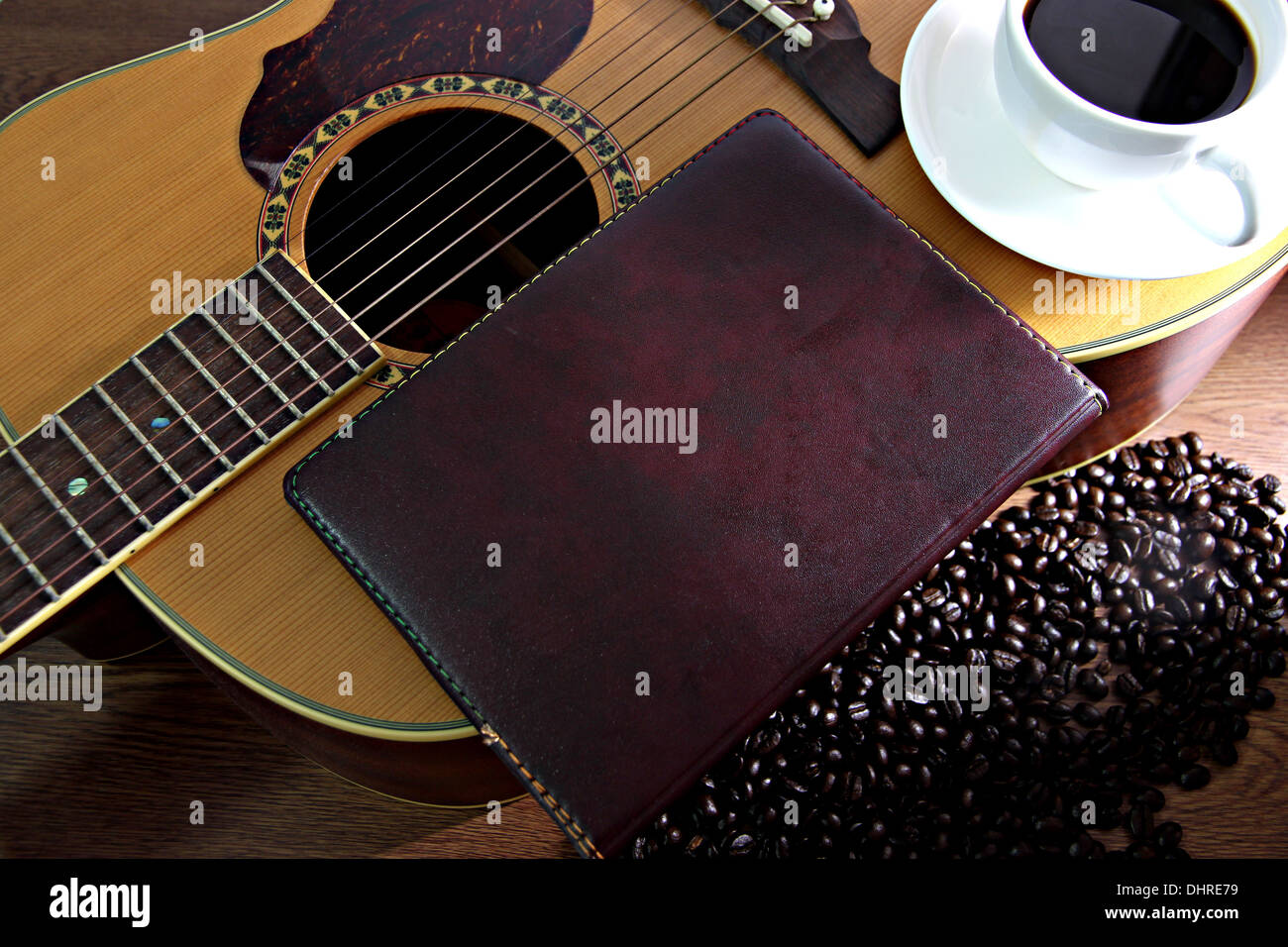 I concetti che White tazza di caffè e vecchia carta nota in appoggio sulla chitarra. Foto Stock